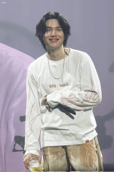 a young man standing in front of a purple background