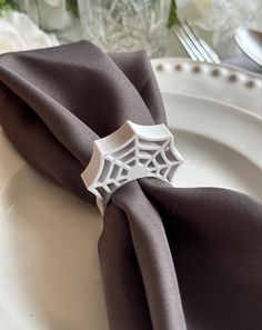 a spider web napkin on top of a white plate