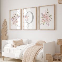 a white bedroom with three framed pictures on the wall