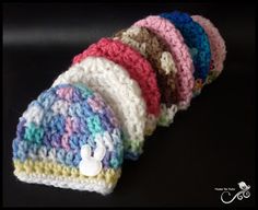 a group of knitted hats sitting on top of a black table next to each other