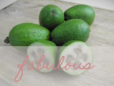 a pile of green fruit sitting on top of a wooden table