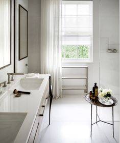 a white bathroom with two sinks and a bathtub