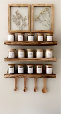 some shelves with jars and spoons hanging on the wall next to two framed pictures