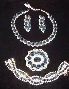 "This fabulous Kramer Suite, 4 Matching Pieces of large sapphire round stones surrounded with small rhinestones.   Adjustable necklace and  clip back Drop earrings.   The  large oval pin has a big oval sapphire stone in the center with small rhinestones surrounding, an outside raised edge of large oval  and round blue stones is finished with a double rhinestone swirling band.  A matching style  bracelet is a double row of rhinestones wit sapphire baguettes in the middle in an overlapping design, Exquisite Evening Jewelry, Evening Crystal Jewelry Sets In Fine Style, Fine Crystal Jewelry Sets For Evening, Evening Crystal Jewelry Sets, Dazzling Oval Jewelry For Evening, Dazzling Oval Evening Jewelry, Luxury Blue Jewelry With Rhinestones, Luxury Blue Rhinestone Jewelry, Dazzling Rhinestone Jewelry Sets For Formal Occasions