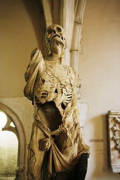 a statue of a skeleton holding a vase