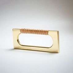 a gold napkin holder with a leather handle