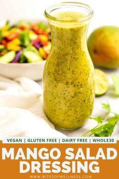 mango salad dressing in a glass jar next to a bowl of fresh fruit and vegetables