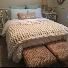 a bed with two wicker foot stools next to it