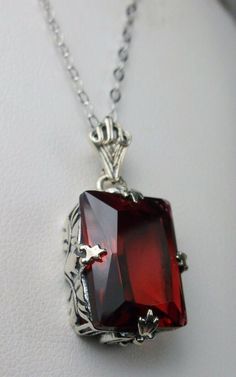 "Simulated Red Ruby Pendant & Earrings GL Design#15 Custom Made Pendant (P15) This is an Art Deco style sterling silver filigree 10 carat Simulated/man-made red ruby pendant necklace. The beautiful rectangle-cut ruby gem is 16mm x 12mm. The 1.5mm necklace chain (if chosen) is adjustable from 18\"-20\". The entire pendant is 1 1/8\" long by 9/16\" wide. Notice the beautiful craftsmanship of the silver Art Deco filigree bail. The earrings are 16mm x 12mm each and 1 5/16\" long. The dazzling ge Vintage Art Deco Necklace, Red Ruby Earrings, Ruby Pendant Necklace, Art Deco Pendant Necklace, London Blue Topaz Earrings, Pink Topaz Ring, Ruby Necklace Pendant, Art Deco Pendant, Ruby Pendant