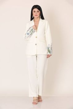 White blazer with floral placement embroidery on the sleeves. Paired with a pant. - Aza Fashions Embroidery Blazers For Women, Tailored Spring Pantsuit With Straight Pants, Spring Tailored Pantsuit With Straight Pants, Tailored Floral Embroidered Blazer For Spring, Workwear Embroidered Blazer With Notch Lapel, Embroidered Notch Lapel Blazer For Work, Tailored Embroidered Blazer For Workwear, Spring Tailored Embroidered Blazer, Spring Tailored Blazer With Embroidery