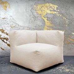 a white chair sitting in front of a wall with gold paint on it's walls