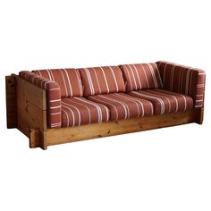 a red and white striped couch sitting on top of a wooden frame