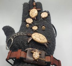 a pair of gloves with turtle buttons and chains attached to the back of one glove