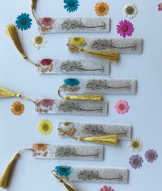 five tassels with different designs and colors are arranged on a white table top