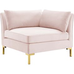 a pink couch with gold legs and pillows