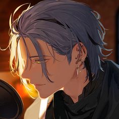 a man with grey hair and ear piercings in front of a microphone looking at something