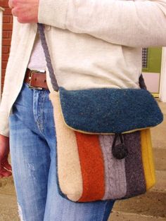 a woman carrying a multicolored purse on her shoulder