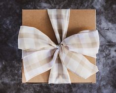 a present wrapped in brown paper with a bow