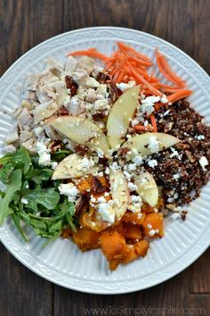 a white plate topped with lots of food on top of a wooden table