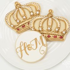 three decorated cookies on a white plate with the word mom spelled in gold and red