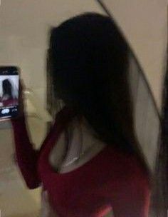 a woman is taking a selfie with her cell phone while standing in front of a mirror