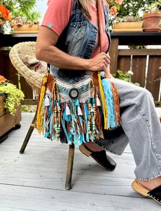 -Get ready to make a statement with our Turquoise Suede Fringe Vegan Leather Saddle Bag, featuring a beautiful saddle brown color that exudes vintage style. This slouchy shoulder bag and sling bag is made from high-quality suede-like fabric and adorned with jewelry, wooden and metallic beads, tassels, and cotton trim to enhance its boho hippie vibe. Our retro purse measures 28cm x 19cm (11"x7.5") and is secured with a zipper closure to keep your belongings safe. You can wear it as a crossbody or Bohemian Turquoise Shoulder Bag, Turquoise Bohemian Shoulder Bag, Blue Bohemian Crossbody Hobo Bag, Blue Tote Hobo Bag For Festivals, Blue Bohemian Satchel Hobo Bag, Bohemian Blue Hobo Satchel Bag, Turquoise Bags For Festivals, Blue Bohemian Hobo Bag, Bohemian Turquoise Travel Bag