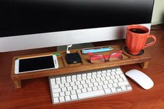 a computer desk with a keyboard, mouse and cell phone on it next to a monitor