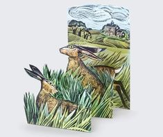 two greeting cards with an image of rabbits in the grass, one has a house on it