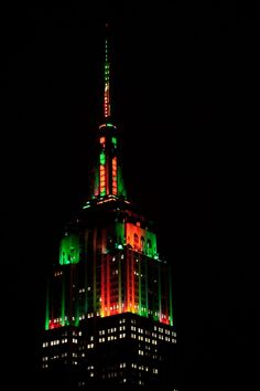 the top of a building lit up in red, green and white lights at night