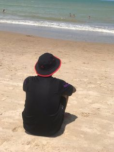 a person sitting on the beach looking out at the ocean