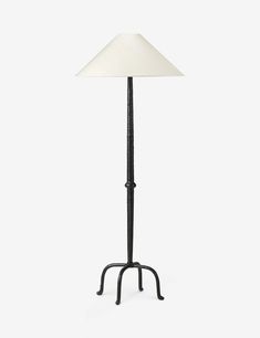 a floor lamp with a white shade on it's base and a black stand