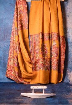 an orange scarf hanging on a clothes rack