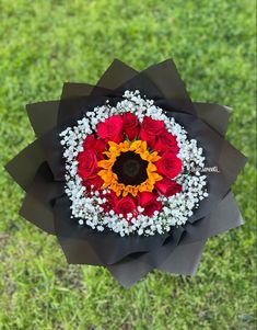 an overhead view of a bouquet of flowers on the ground with grass in the background