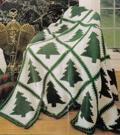 there is a crocheted christmas tree afghan on the floor