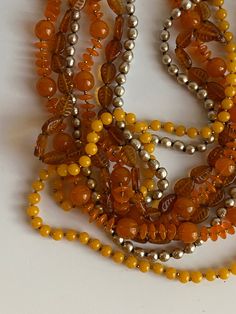 Early vintage Miriam Haskell four strand beaded necklace with matching clip-on earrings. Made up of orange and amber colored glass beads and silver faux baroque pearl beads. The amber color glass beads have cut lines to make the beads look like leaves. Necklace measures 28" in length and the earrings are approximately 1 1/2". Very good previously owned vintage condition. Please view all photos as part of this description. I am always happy to respond to questions. This item will ship USPS. Vintage Amber Jewelry With Large Beads, Elegant Amber Beaded Necklaces With Large Beads, Vintage Multi-strand Beaded Necklace With Polished Beads, Formal Amber Beaded Jewelry, Amber Beaded Jewelry For Party, Elegant Amber Jewelry With Large Beads, Orange Vintage Jewelry With Faceted Beads, Amber Beaded Jewelry For Formal Occasions, Vintage Amber Jewelry With Colorful Beads