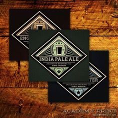 two business cards with the words india pale ale and beer on them, against a wooden background