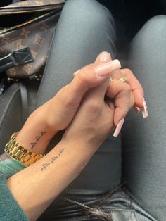 a woman with her hand on the wrist of another person