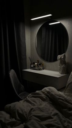 a dark room with a bed, mirror and desk