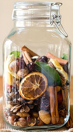 a glass jar filled with different types of food on top of a wooden table next to an orange slice