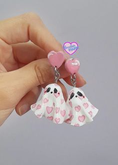 two little white dogs with pink hearts hanging from their earring sets in the shape of hearts