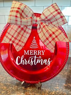 a red christmas plate with a bow on it sitting on top of a kitchen counter