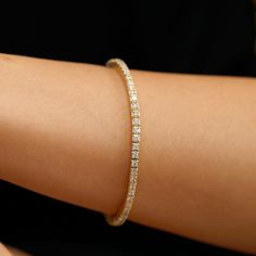 Freja This stunning bracelet seamlessly blends classic design with modern innovation. Featuring a row of sparkling diamonds, meticulously cut and polished to maximize their brilliance. This versatile piece seamlessly combines the elegance of a tennis bracelet with the comfort of a stretch flex design. Pick your favorite from yellow, white, or rose gold. - Handmade - Solid Gold- Natural Diamonds - G Color, SI Quality Diamonds- Total Diamond Carat Weight: 1.90 ctw for size 7- Setting Width 2.7 mm Luxury Dazzling Diamond Tennis Bracelet, Classic Flexible Tennis Bracelet With Round Cut, Classic Flexible Cubic Zirconia Diamond Bracelet, Flexible Diamond White Cubic Zirconia Tennis Bracelet, Modern Cubic Zirconia Tennis Bracelet With Brilliant Cut, Diamond White Jubilee Tennis Bracelet, Modern Yellow Gold Tennis Bracelet With Prong Setting, Flexible Diamond Tennis Bracelet, Modern Yellow Gold Tennis Bracelet With Vvs Clarity