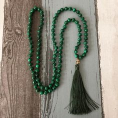 This Malachite Beaded Japa Mala Necklace is a traditional prayer necklace made from beautiful green Malachite beads. It is believed that using a Japa Mala during meditation and prayer can help calm the mind and deepen spiritual awareness. The benefits of using a Japa Mala include promoting mindfulness, increasing focus, and helping to connect with a higher power. The Malachite stone is known for its healing properties and is believed to protect the wearer from negative energies while promoting e Spiritual Malachite Necklace For Healing, Traditional Jade Necklaces For Meditation, Traditional Jade Necklace For Meditation, Spiritual Jade Beads For Meditation, Green Spiritual Beads For Healing, Traditional Green Necklace For Meditation, Spiritual Malachite Gemstone Beads Necklace, Green Spiritual Beads, 108 Count, Green Hand-strung Spiritual Mala