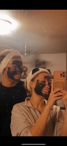 two people with facial masks on taking a selfie