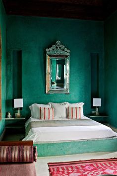 a bedroom with green walls and white bedding