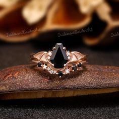 a black diamond ring sitting on top of a piece of wood