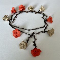 a necklace with crocheted flowers and leaves