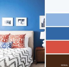 a bedroom with blue walls and white bedding, red pillows and pictures on the wall