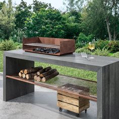 an outdoor table with firewood, wine glass and grill in the backgroud