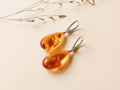 "Light orange natural amber earrings for women that love bright eye-catching colors. These drop shape genuine amber earrings brighten up your eyes. And we've heard - some lives too! Even though they are in cognac color, all they do is sweetens your life.   MATERIALS AND SIZE: Stone: 100% Natural Baltic Amber Findings: Sterling silver 925 Weight: 5,4g  (0,19oz)                                                     Bead size: 2,9cm (1,14 in) x 1,4 cm (0,55in) Total length: 4,8cm (1,88 in) PLEASE NOT Bright Eye, Cognac Color, Unusual Earrings, Amber Earrings, Natural Amber, Wedding Jewelry Earrings, Amber Jewelry, Earrings Drop, Jewelry Inspo